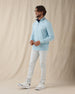 Men's Cimarron Quarter Zip in Delphinium, full-length side view on male model in soft sky blue styled with white pants and white golf shoes against a neutral linen backdrop