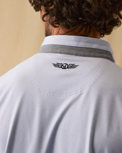 Men's Cimarron Quarter Zip in Lavender, close-up detail of embroidered winged logo at center back neck with grey heathered collar visible above