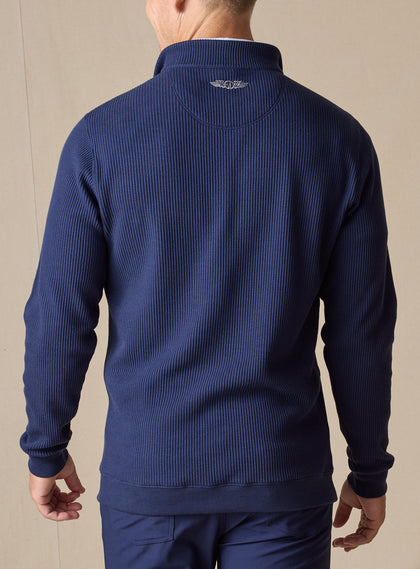 Men's Cambria Quarter Zip in New Indigo, back on-model view featuring a navy ribbed knit fabric with an embroidered Straight Down logo at the yoke, styled with navy pants