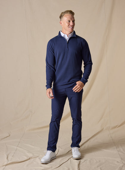 Men's Cambria Quarter Zip in New Indigo, full-length on-model view featuring a navy ribbed knit fabric with a quarter zip closure, styled with navy pants and white shoes