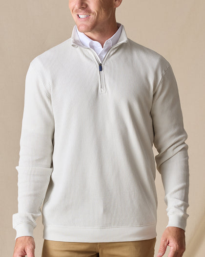 Men's Cambria Quarter Zip in Stone, front on-model view featuring a cream white ribbed knit fabric with a quarter zip closure and white interior collar, styled with tan pants
