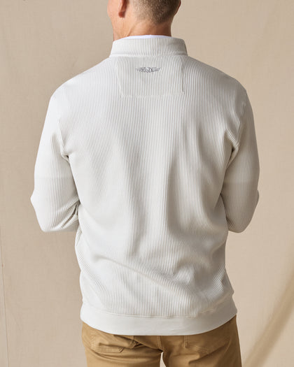 Men's Cambria Quarter Zip in Stone, back on-model view featuring a cream white ribbed knit fabric with an embroidered Straight Down logo at the yoke, styled with tan pants