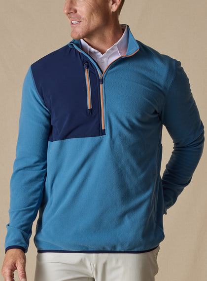 Men's Moonstone Quarter Zip in Petrol, front model view featuring a medium blue micro-fleece body with navy contrast chest panel and orange zipper tape