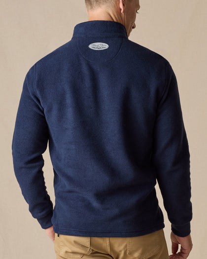 Men's Leucadia Quarter Snap Pullover in Indigo, back model view featuring a logo patch at the upper back yoke, styled with khaki pants