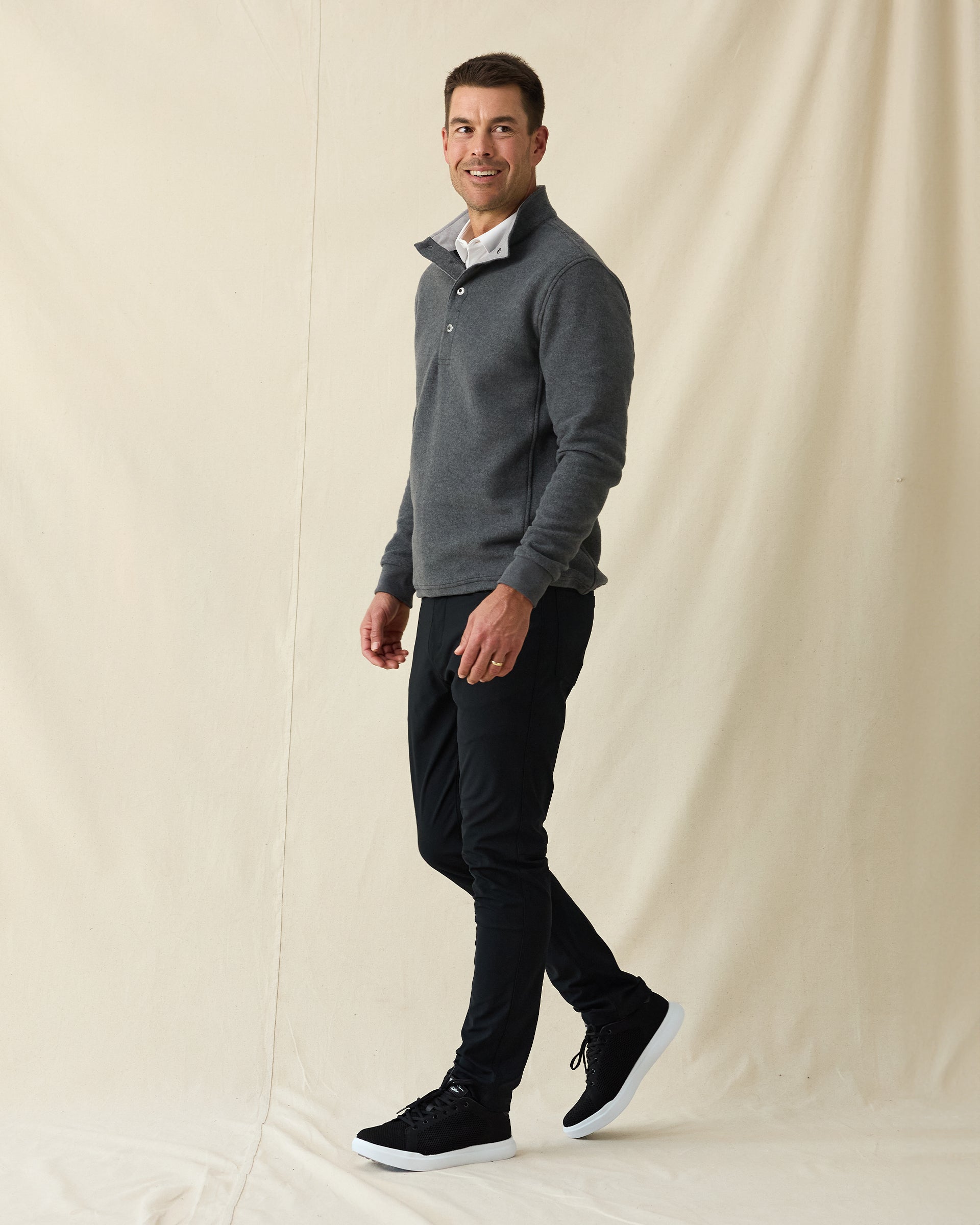 Men's Leucadia Quarter Snap Pullover in Charcoal, full length side view on model featuring a charcoal heather fleece with snap closure neckline, paired with black pants and black shoes