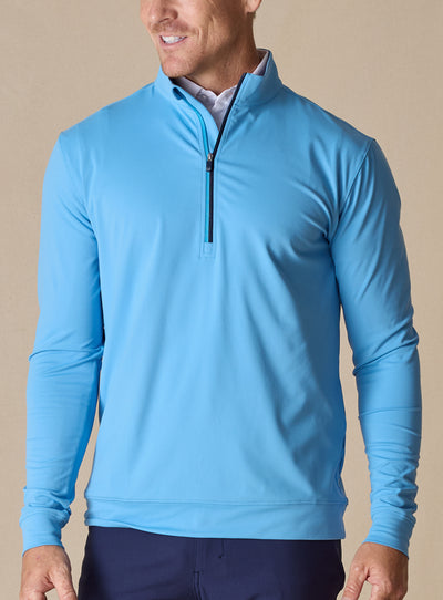 Men's Patron Quarter Zip in Niagara, front view in solid light blue with a navy quarter zip closure, paired with navy pants