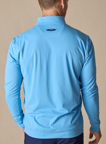 Men's Patron Quarter Zip in Niagara, back view in solid light blue with Straight Down logo at the upper back, paired with navy pants