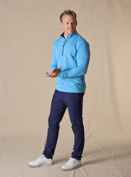 Men's Patron Quarter Zip in Niagara, full-length front view in solid light blue, paired with navy pants and white golf shoes