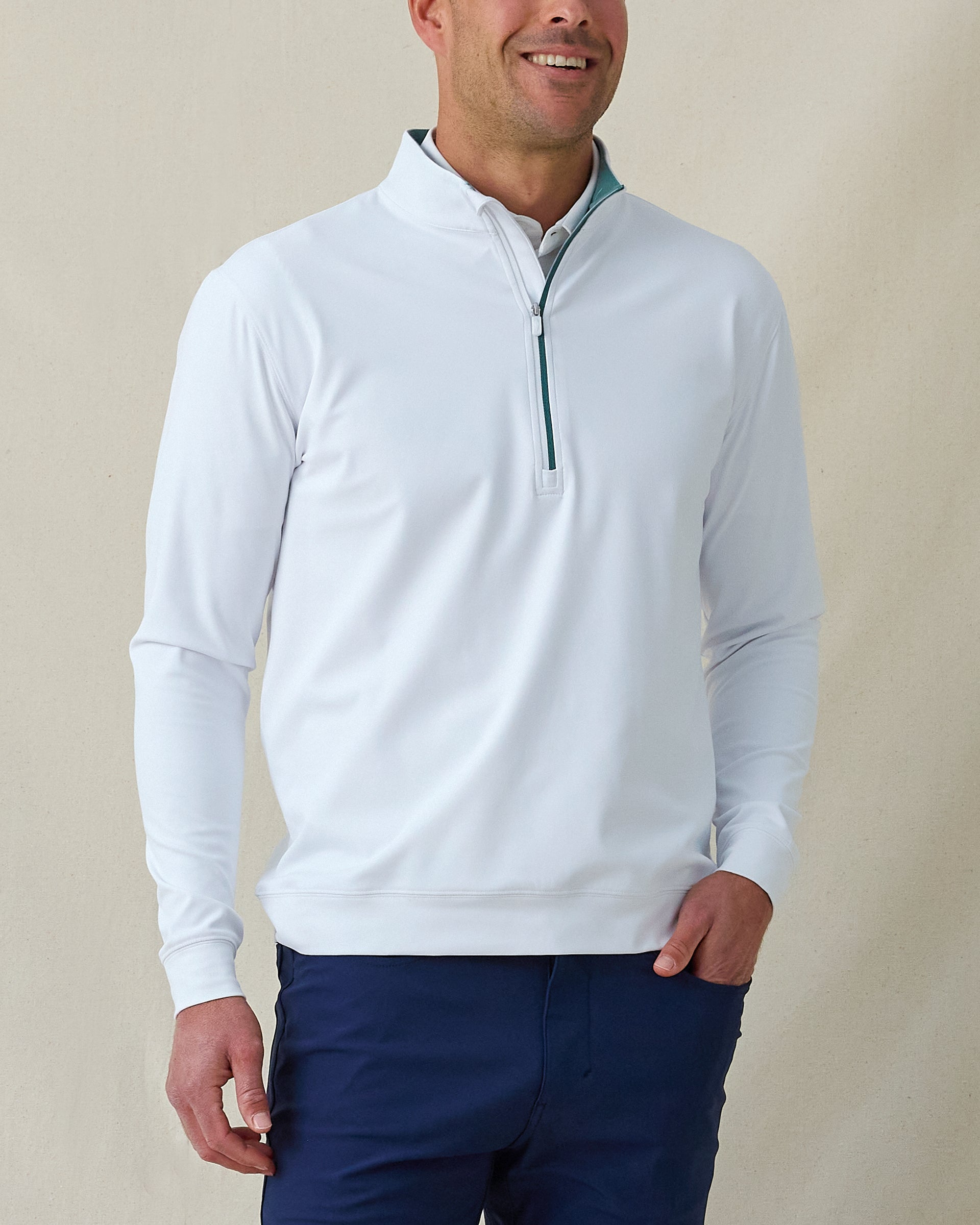 Men's Patron Quarter Zip in White Sage, front view on model featuring a white base with a quarter zip closure and sage contrast zipper and collar lining detail, paired with navy pants