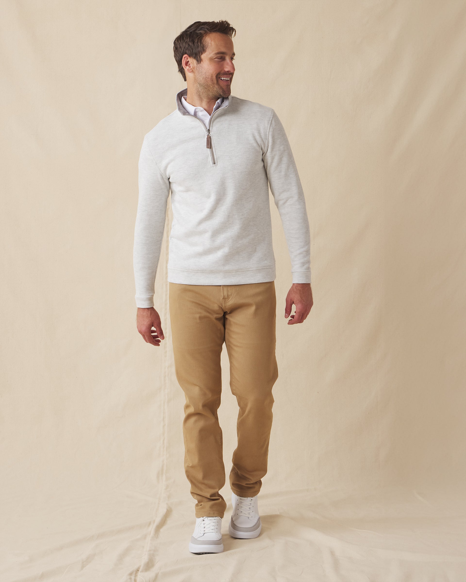 Men's Montecito Quarter Zip in Heather, full length front view on model featuring a light heather gray ribbed knit with silver quarter zip, paired with tan pants and white shoes