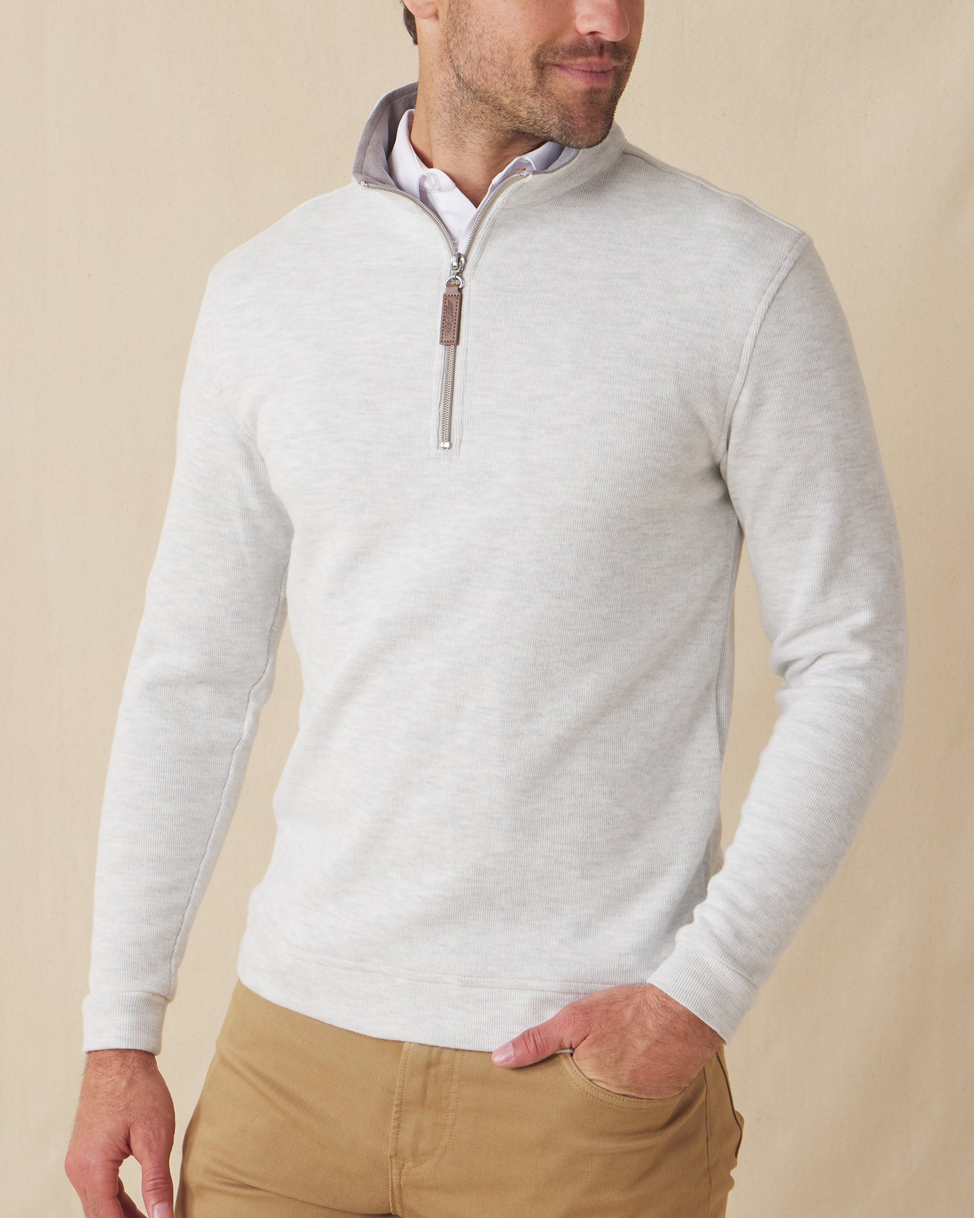 Men's Montecito Quarter Zip in Heather, front view on model featuring a light heather gray ribbed knit with silver quarter zip and leather zip pull, paired with tan pants