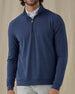 Men's Tiburon Quarter Zip in New Indigo, front view on model featuring a solid heathered navy body with a quarter zip neckline, layered over a white polo, paired with light gray pants