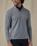 Men's Tiburon Quarter Zip in Storm, front view on model featuring a heathered gray solid fabric with a quarter zip placket and mock neck collar, layered over a black polo, paired with black pants