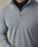 Men's Tiburon Quarter Zip in Storm, close-up on-model detail view featuring a heathered gray solid fabric with a metal quarter zip pull and mock neck collar, layered over a black polo