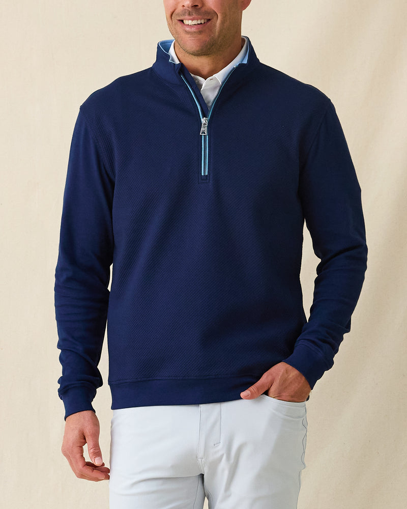 Men's Cardiff Quarter Zip in New Indigo, front model view featuring a navy long sleeve quarter zip pullover with a textured raised diamond fabric and light blue contrast zip placket, layered over a white polo, styled with light gray pants