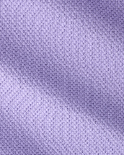 A close-up of a light purple textured fabric with a fine woven pattern and soft diagonal shadows.