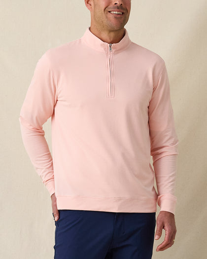 Men's Palmetto Quarter Zip in Spritz, front model view featuring a light pink long sleeve quarter zip pullover with a smooth performance fabric and silver zip hardware, layered over a white polo, styled with navy pants