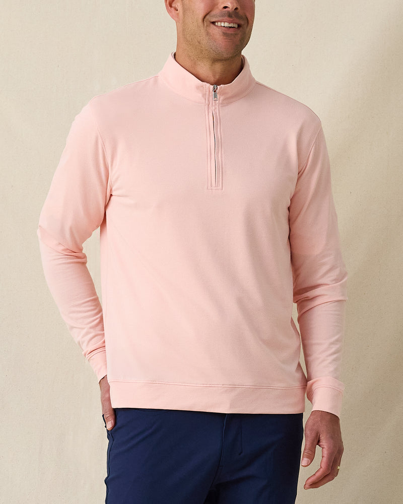 Men's Palmetto Quarter Zip in Spritz, front model view featuring a light pink long sleeve quarter zip pullover with a smooth performance fabric and silver zip hardware, layered over a white polo, styled with navy pants