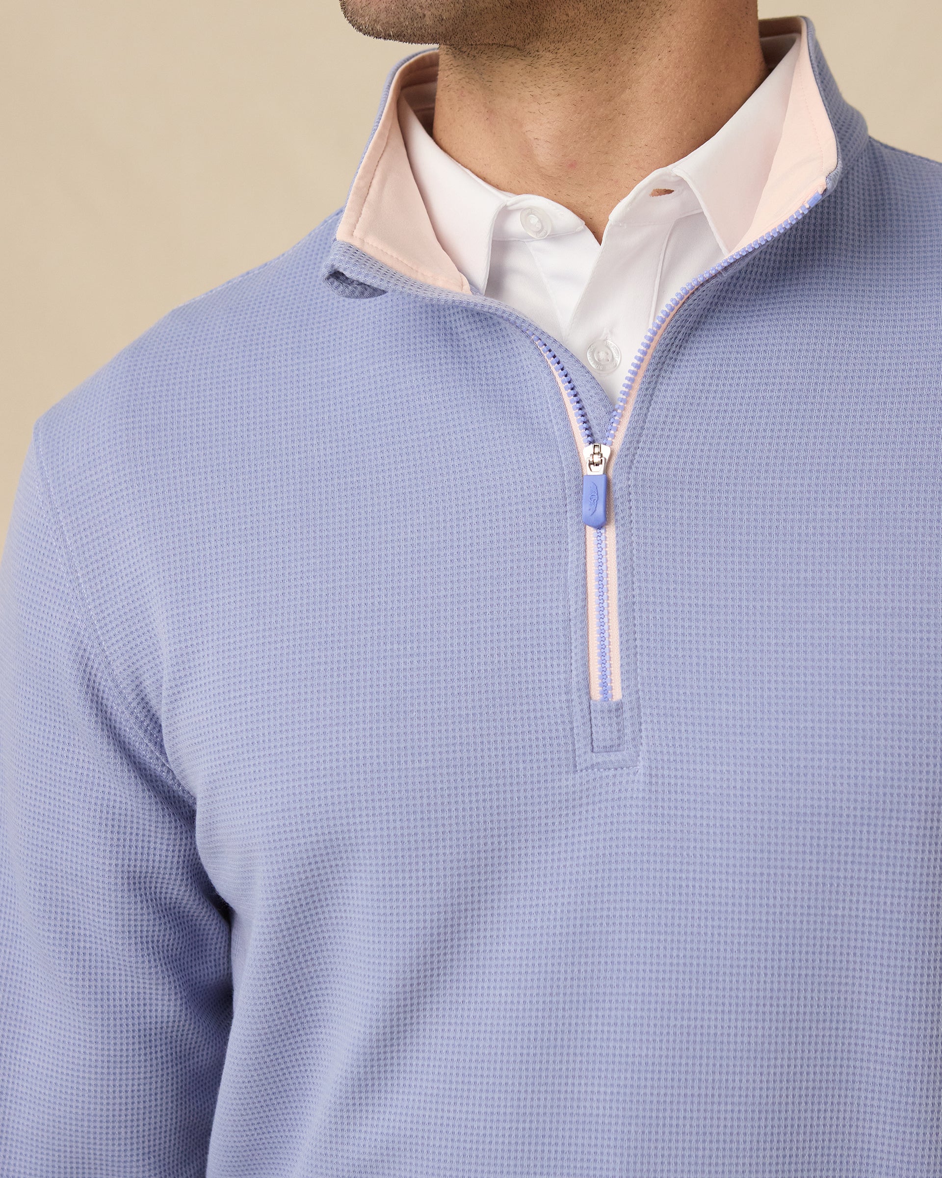 Close-up of the stand collar, blush trim and quarter-zip neckline.