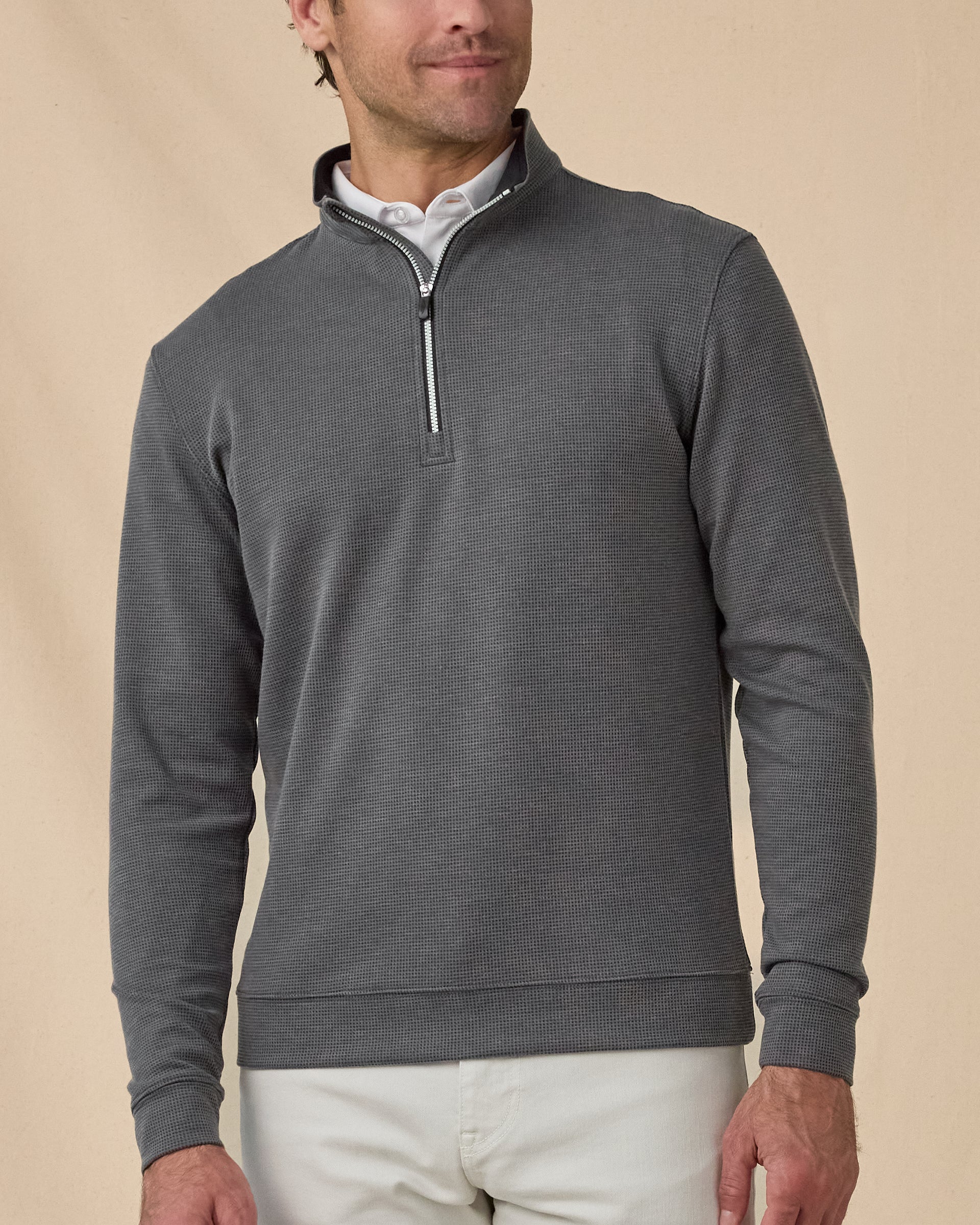 Model wearing the Warren Quarter Zip in Black layered over a white polo, showing the textured knit and quarter-zip neckline.