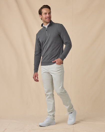 Full-length view of model wearing the Warren Quarter Zip in Black with white pants and white sneakers.