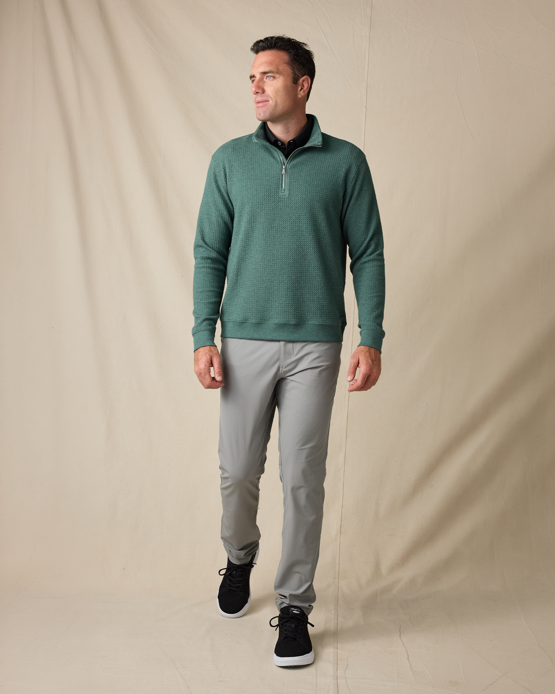 Model wearing the Topanga Quarter Zip in Dark Forest with gray pants and black sneakers.