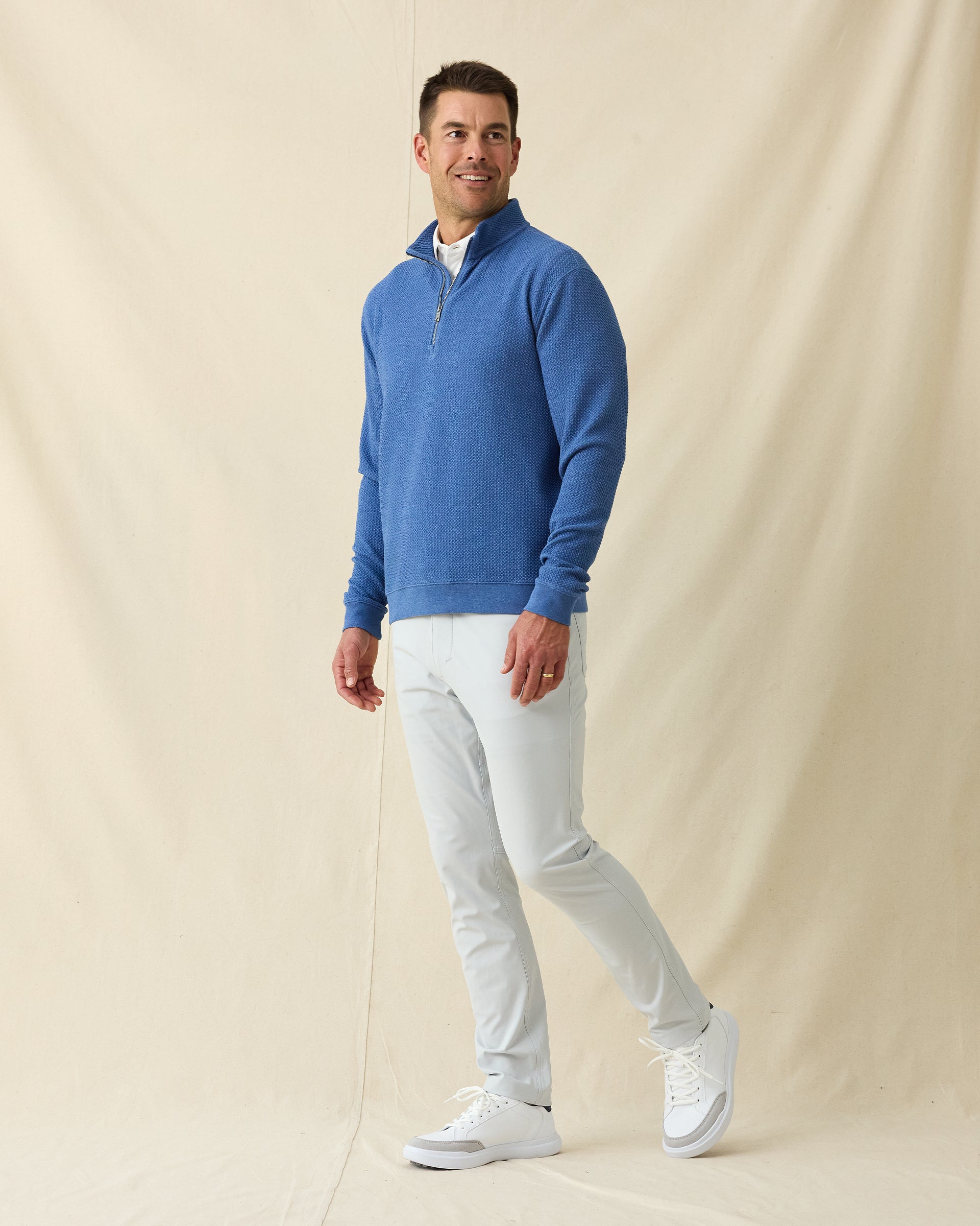 Men's Topanga Quarter Zip in Moonlight, full length front view on model featuring a bubble knit texture with silver zipper, layered over a white polo, paired with white pants and white shoes