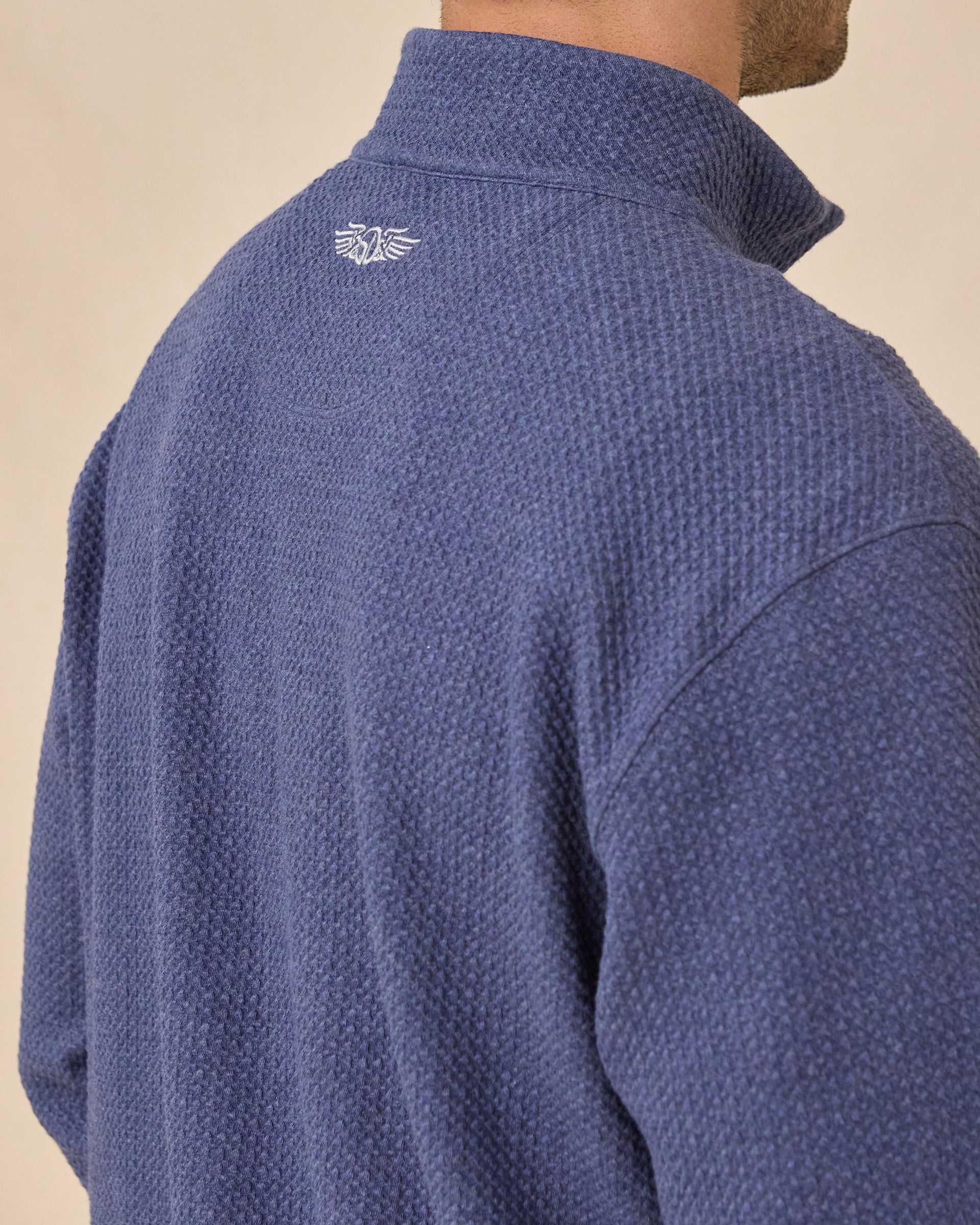 Close-up back view of the Topanga Quarter Zip in New Indigo highlighting the textured knit fabric and embroidered logo below the collar