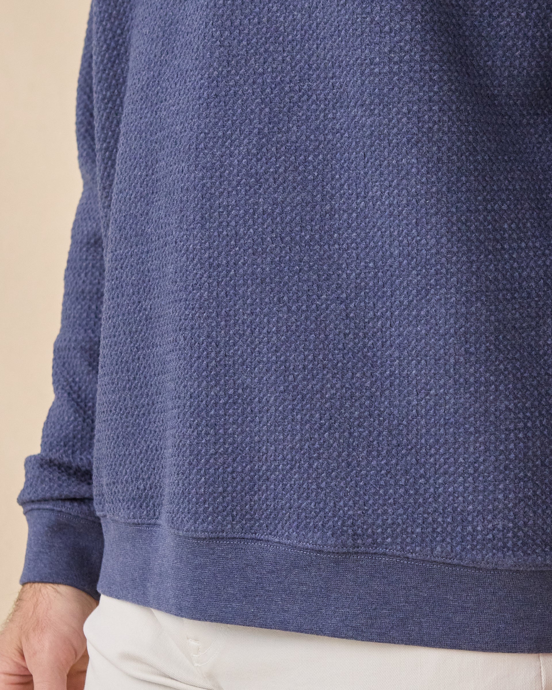 Close-up of the Topanga Quarter Zip in New Indigo showcasing the textured knit fabric and ribbed hem construction