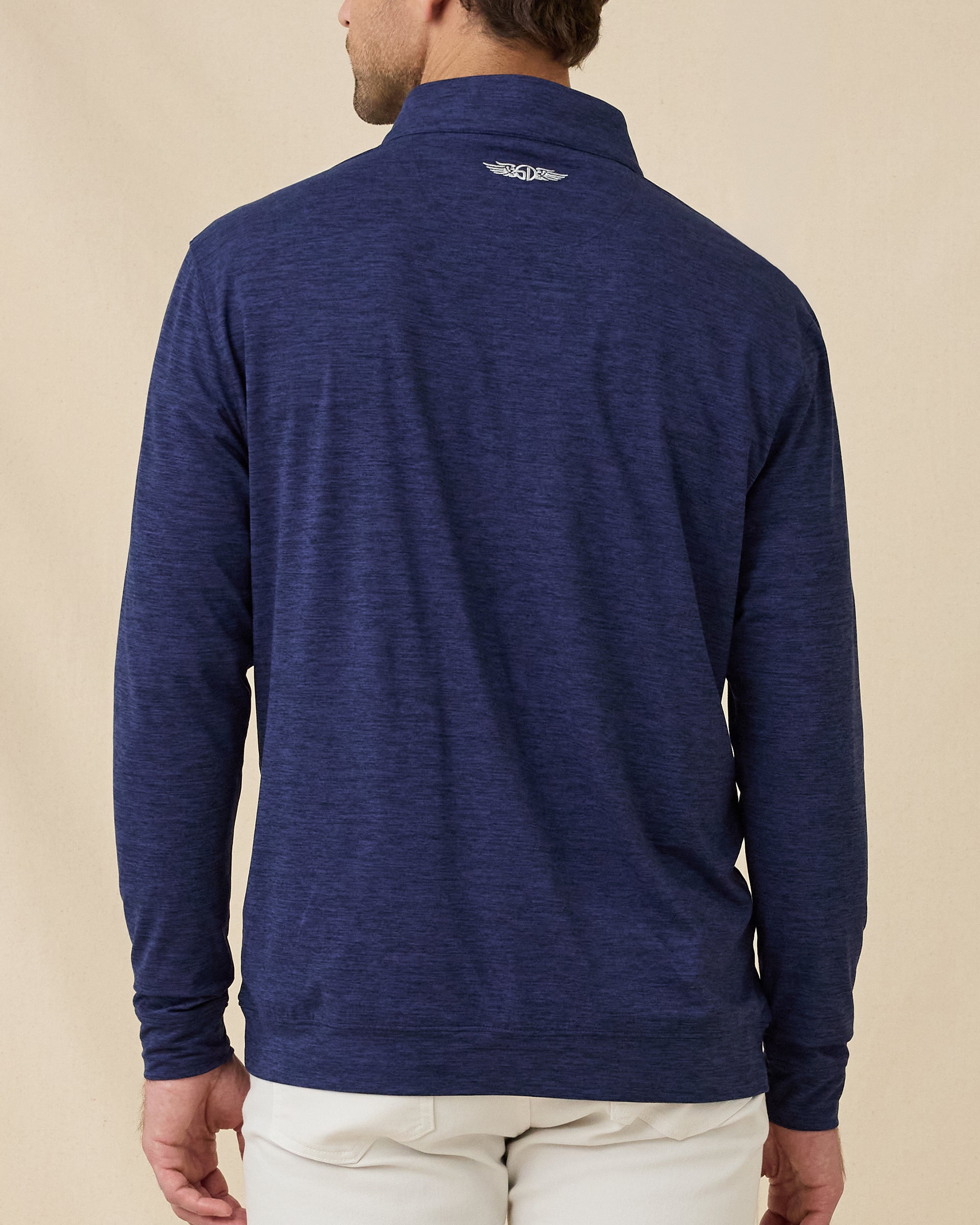Back view of a male model wearing the Palmer Quarter Zip in New Indigo, showing the clean silhouette and embroidered logo below the collar.