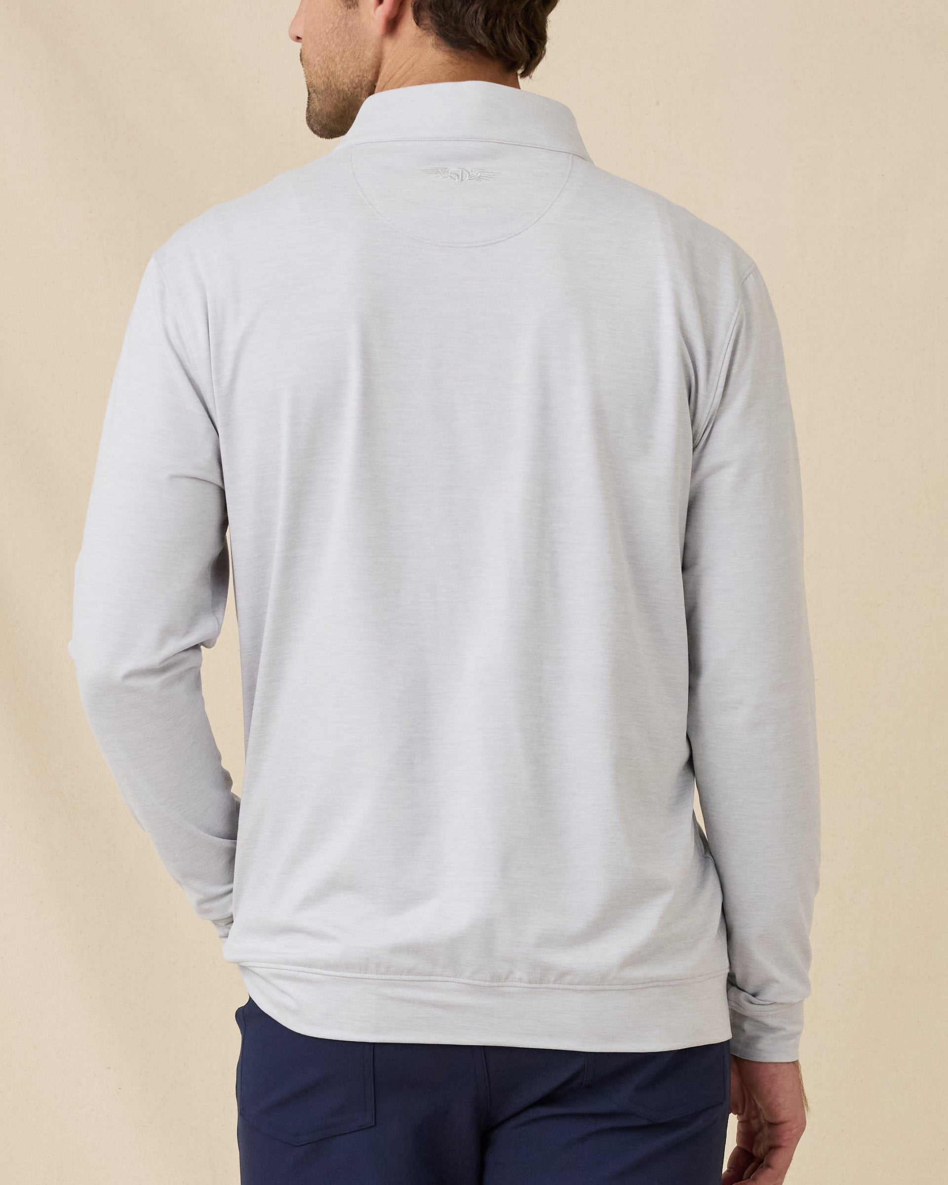 Back view of model wearing the Palmer Quarter Zip in Heather, showing the clean back design and embroidered logo below the collar.