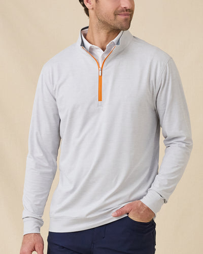Model wearing the Palmer Quarter Zip in Heather over a white polo, showing the light heathered fabric and contrasting orange quarter-zip detail.