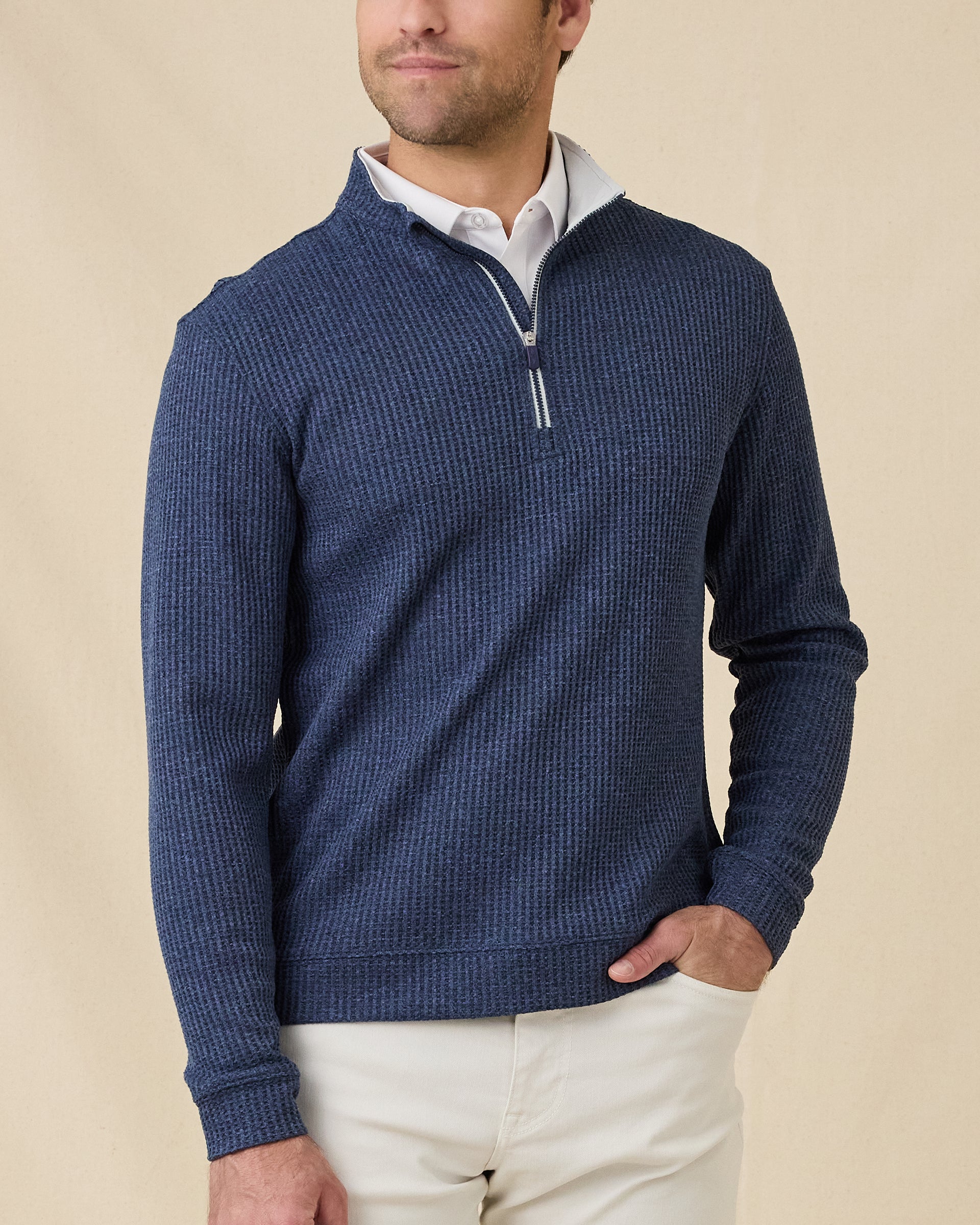 Male model wearing the Huntington Quarter Zip in New Indigo layered over a white polo, showing the textured knit and relaxed quarter-zip collar.