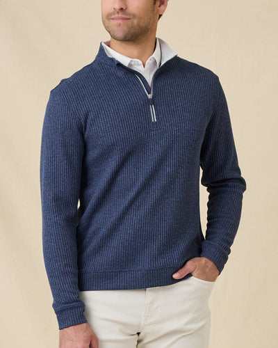 Male model wearing the Huntington Quarter Zip in New Indigo layered over a white polo, showing the textured knit and relaxed quarter-zip collar.