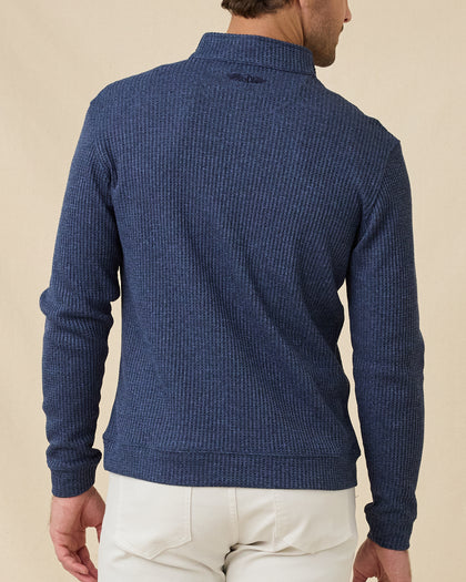 Back view of a male model wearing the Huntington Quarter Zip in New Indigo, highlighting the textured waffle knit and embroidered logo below the back collar.