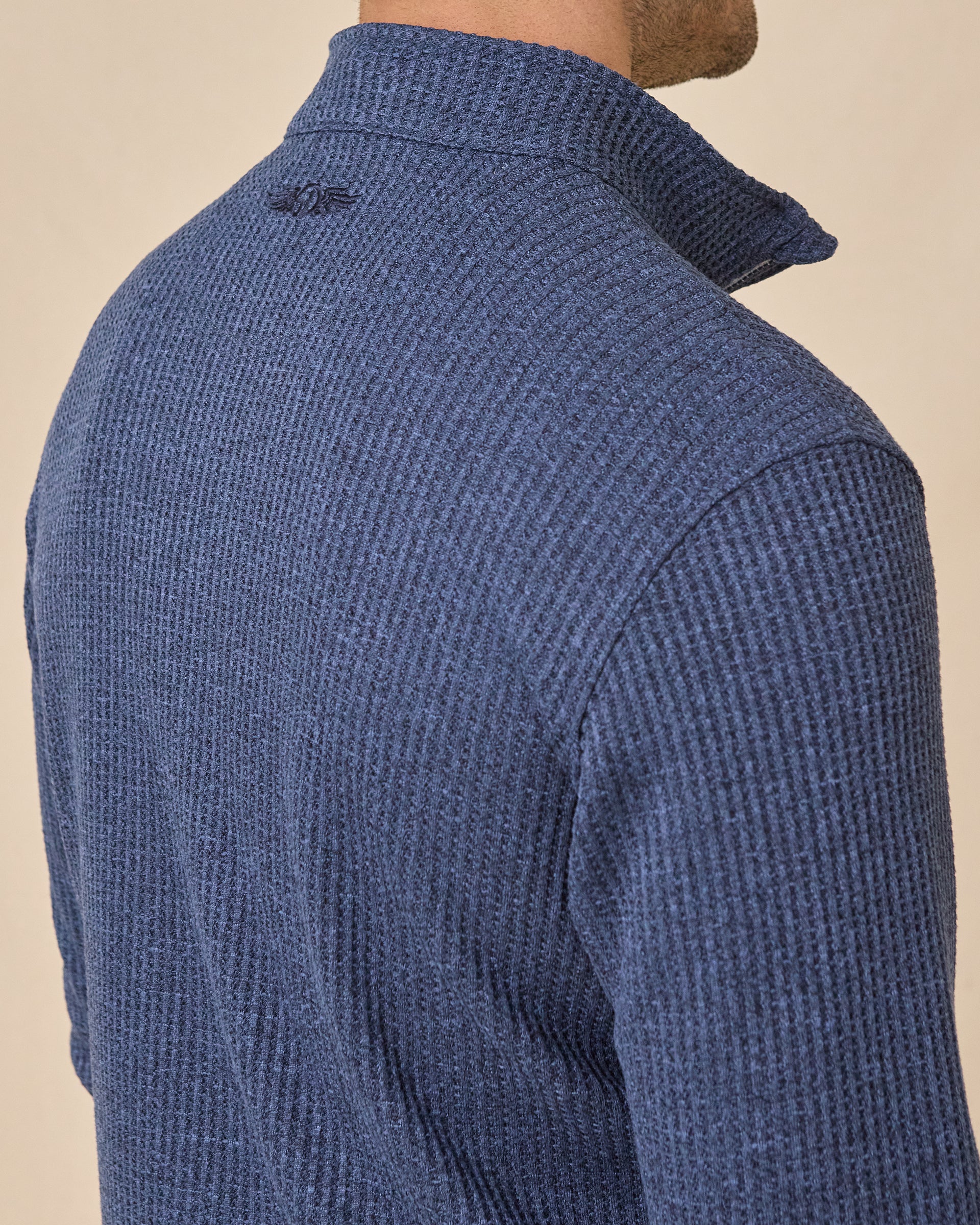 Close-up back view of the Huntington Quarter Zip in New Indigo, highlighting the textured knit and tonal embroidered logo below the collar.