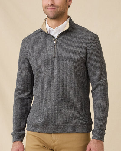 Model wearing the black Huntington Quarter Zip layered over a white polo with tan pants.