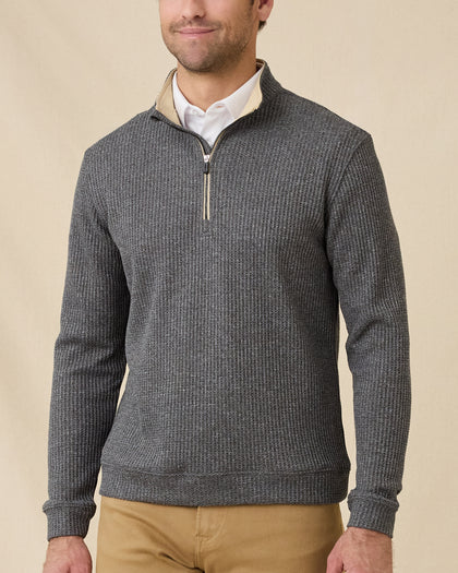Model wearing the black Huntington Quarter Zip layered over a white polo with tan pants.