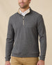 Model wearing the black Huntington Quarter Zip layered over a white polo with tan pants.
