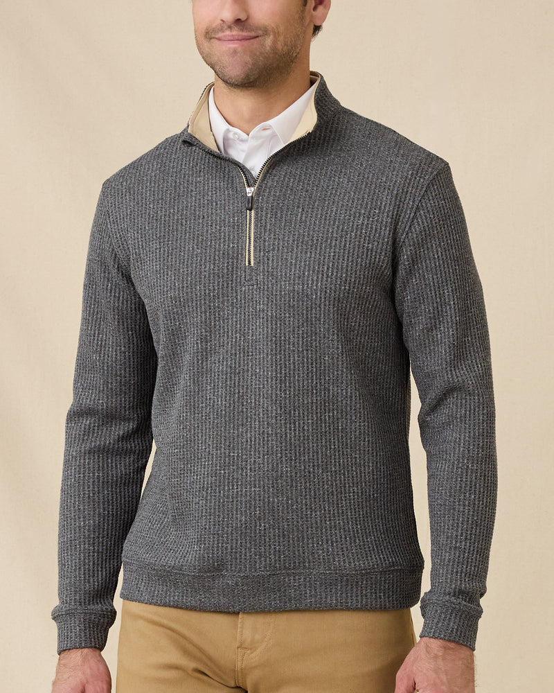 Model wearing the black Huntington Quarter Zip layered over a white polo with tan pants.
