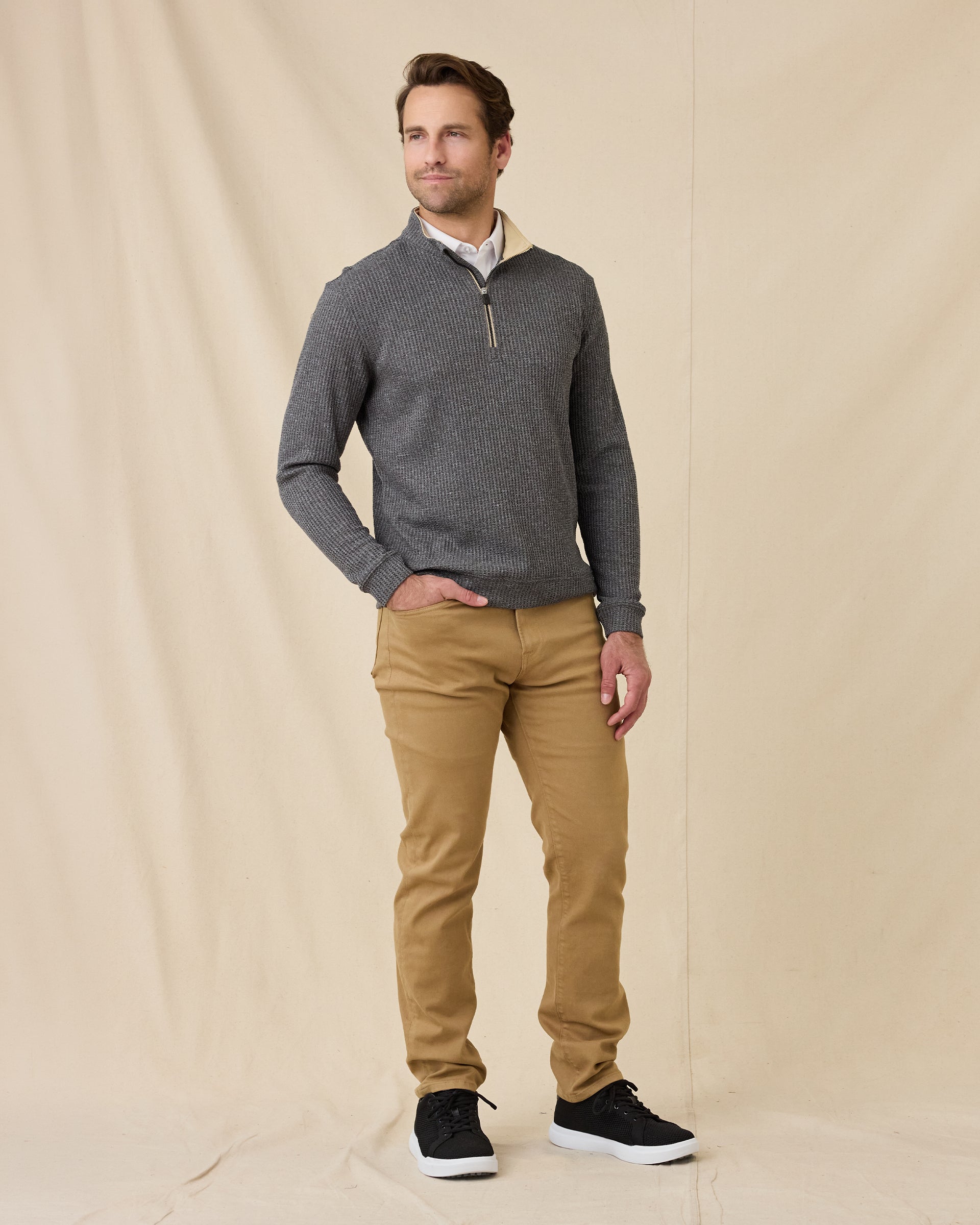 Model wearing the black Huntington Quarter Zip with tan pants and black sneakers.