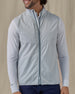 Men's Zephyr Hybrid Vest in Silver, front view on model featuring a solid light gray body with a full zip closure and mock neck, layered over a white polo and long sleeve, paired with navy pants