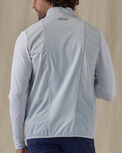 Men's Zephyr Hybrid Vest in Silver, back view on model featuring a solid light gray body with a Straight Down logo embroidered at the upper back, layered over a white long sleeve, paired with navy pants