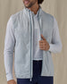 Men's Zephyr Hybrid Vest in Silver, front view on model with vest unzipped featuring a solid light gray body with a full zip closure, layered over a white polo and long sleeve, paired with navy pants