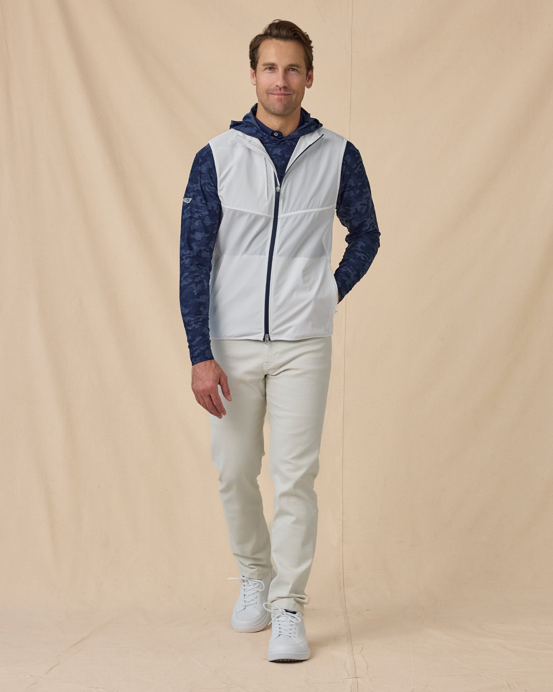 Men’s Zephyr Hybrid Vest in White / New Indigo, styled full outfit view with dark hoodie and light pants