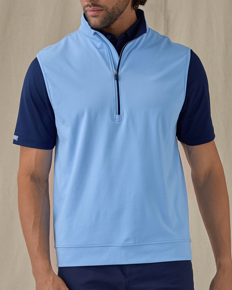 Men's Carson Vest in Carolina, on model front view highlighting the light blue body with navy quarter zip and navy collar interior layered over a navy polo