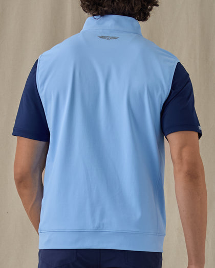 Men's Carson Vest in Carolina, on model back view showing the Straight Down logo at the upper back and light blue body layered over a navy polo