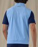Men's Carson Vest in Carolina, on model back view showing the Straight Down logo at the upper back and light blue body layered over a navy polo