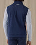 Men's Carson Vest in New Indigo, on model back view showing the Straight Down logo at the upper back layered over a white long sleeve top