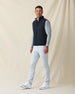 Men's Delta 2.0 Quilted Hybrid Vest in Black, full length side view on model featuring a black quilted front panel with full zip closure, layered over a gray long sleeve shirt, paired with white pants and white shoes